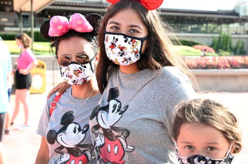 In hard-hit Florida the Walt Disney World theme park partially reopened after four months of shutdown, with some visitors combin