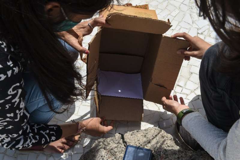 In India's Gujarat, members of a state science council watched the eclipse safely using a pinhole box