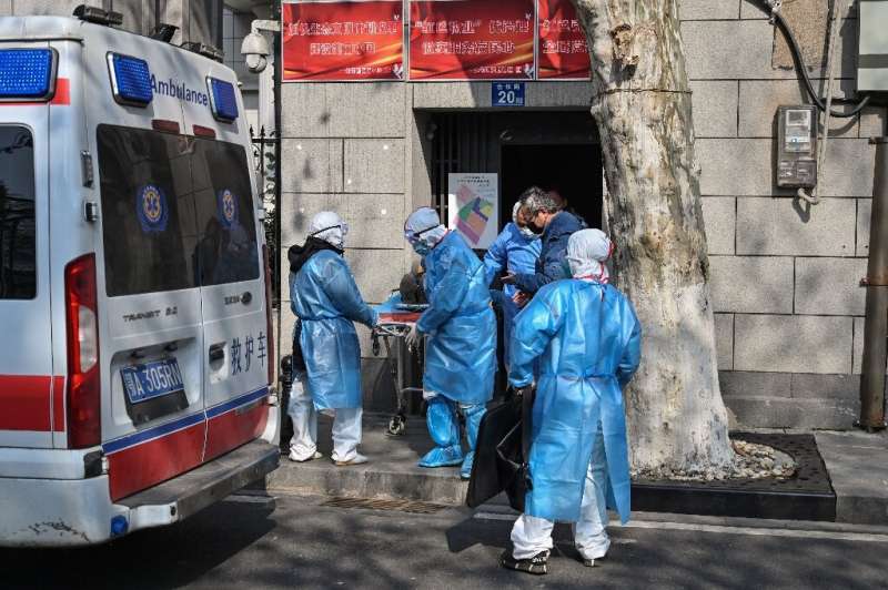 Medical staff in protective clothing carry a suspected virus patient from an apartment in Wuhan