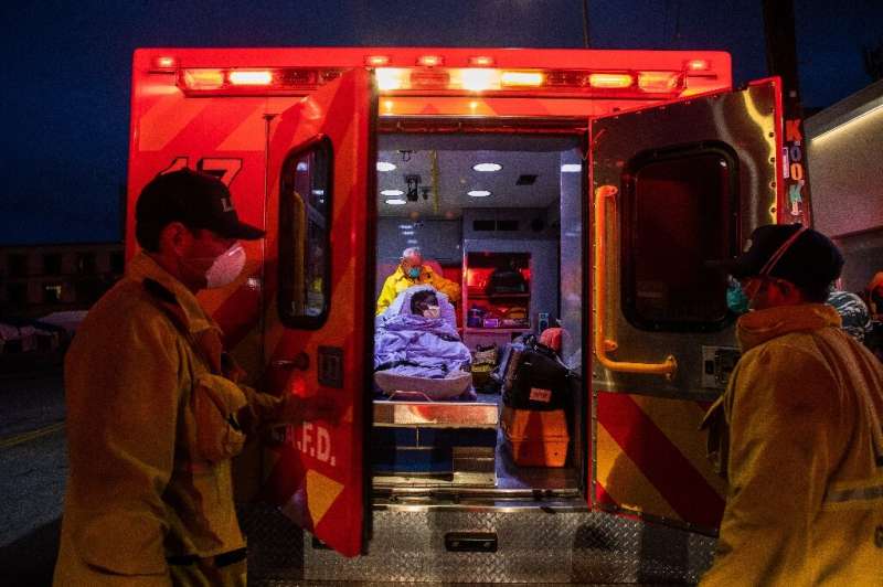 Paramedics take a homeless woman to hospital in Los Angeles, California