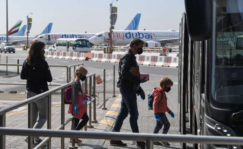 Passengers bound for Frankfurt board a shuttle bus at Dubai airport as UAE carriers Emirates Airlines and Etihad Airways resume 