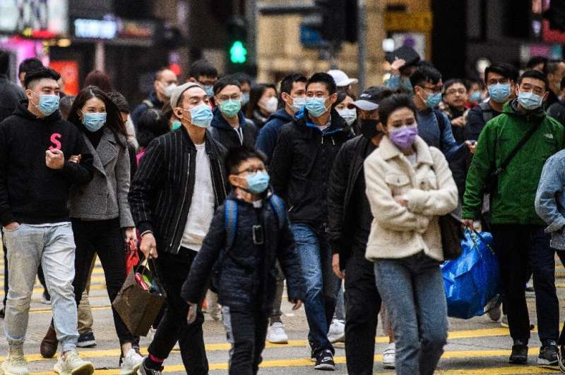Pedestrians wearing face masks cross a road during a Lunar New Year of the Rat public holiday in Hong Kong on January 27, 2020, 
