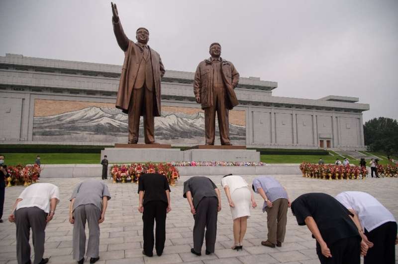 People bow as they pay their respects before the statues of late North Korean leaders Kim Il Sung and Kim Jong Il as the country