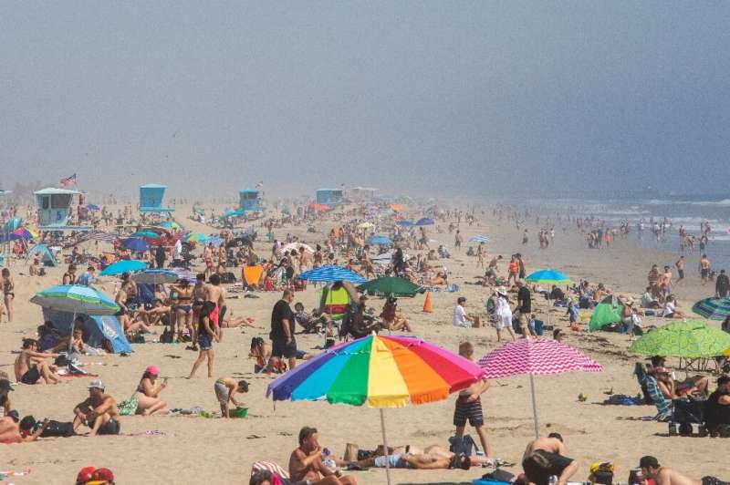 People enjoy the sun and sand amid the novel coronavirus pandemic in Huntington Beach, California