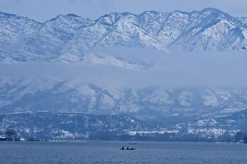 People ride on boats in the Dal Lake after heavy snowfall in Srinagar, Indian-administered Kashmir