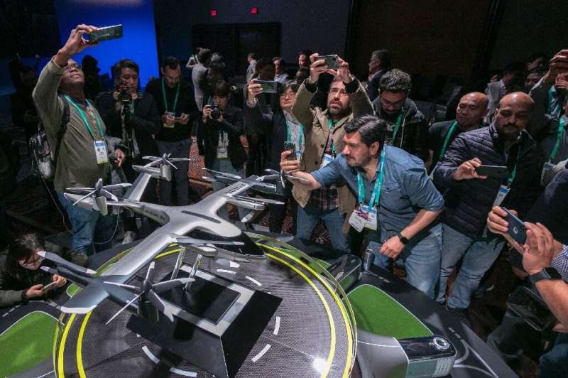 People take photos of a model of Hyundai's S-A1 electric vertical takeoff and landing (eVTOL) aircraft built in partnership with
