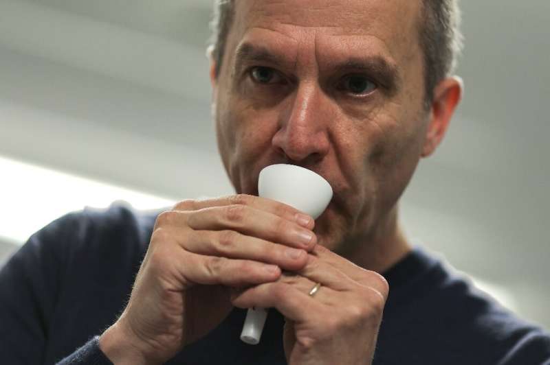 Professor Fabrice Bureau demonstrates how to use the saliva tests, which consist of a tube with a funnel for easy collection