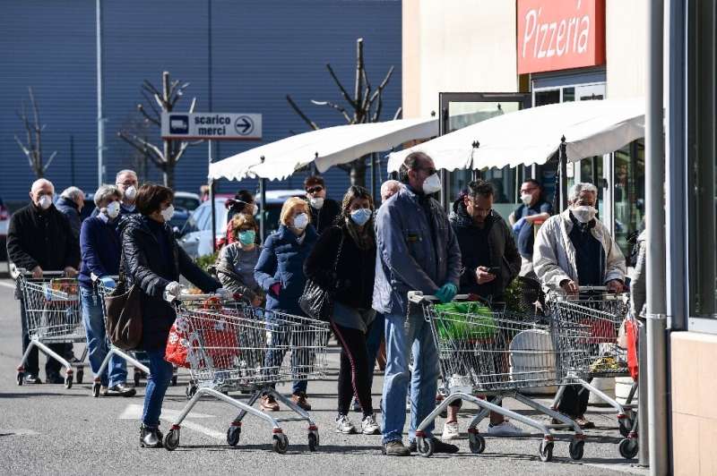Residents queue up outside a supermarket in Codogno, southeast of Milan