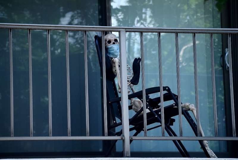 Someone with a morbid sense of humor placed this Halloween skeleton wearing a face mask on an apartment balcony in Washington DC