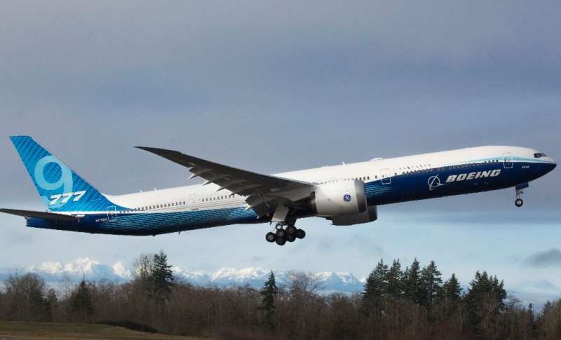 The snow-covered Olympic Mountains are pictured in the background as a Boeing 777X airplane takes off on its inaugural flight at