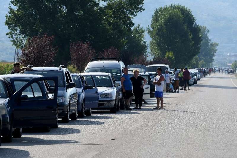 Thousands of Albanians queued in their cars at the Greek border, hoping to squeeze across and return to work before tougher entr