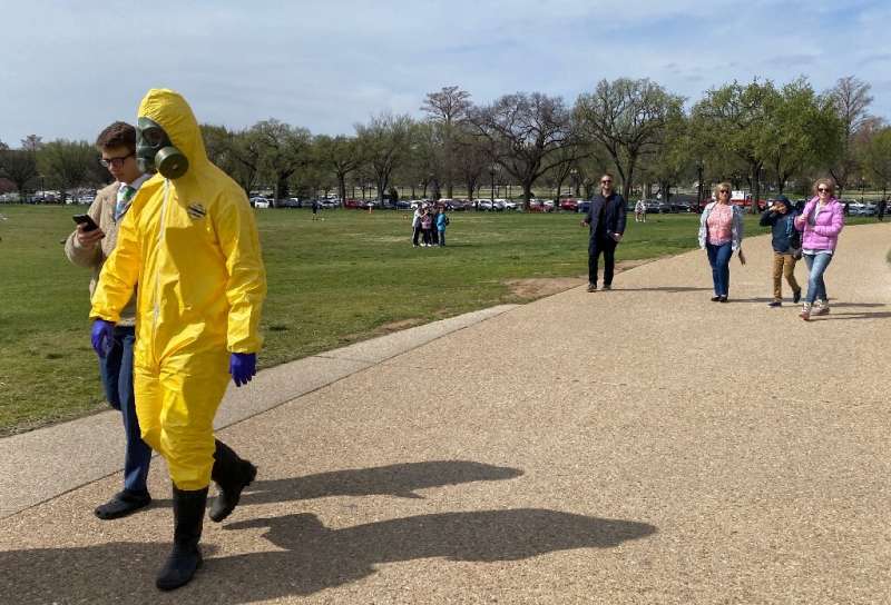Tourists walk around the Washington monument despite recommendations for &quot;social distancing&quot; to protect against the co