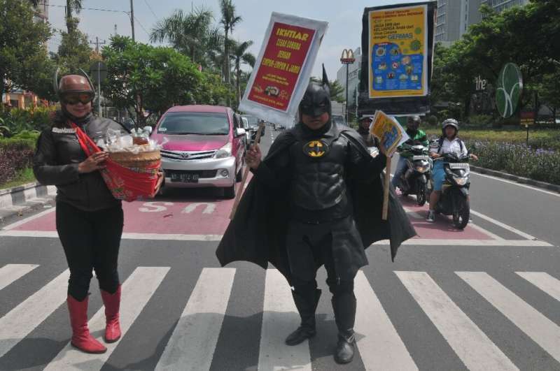 Vendors wearing outfits of local superhero Gundala and Batman hawk traditional Indonesian herbal drinks known as &quot;jamu&quot