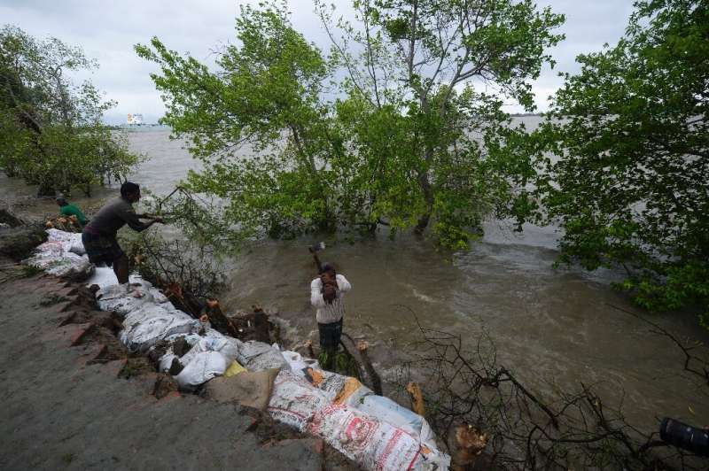 Villagers reinforce an embankment with sacks of soil ahead of the expected landfall of Cyclone Amphan, in Dacope, Bangladesh on 
