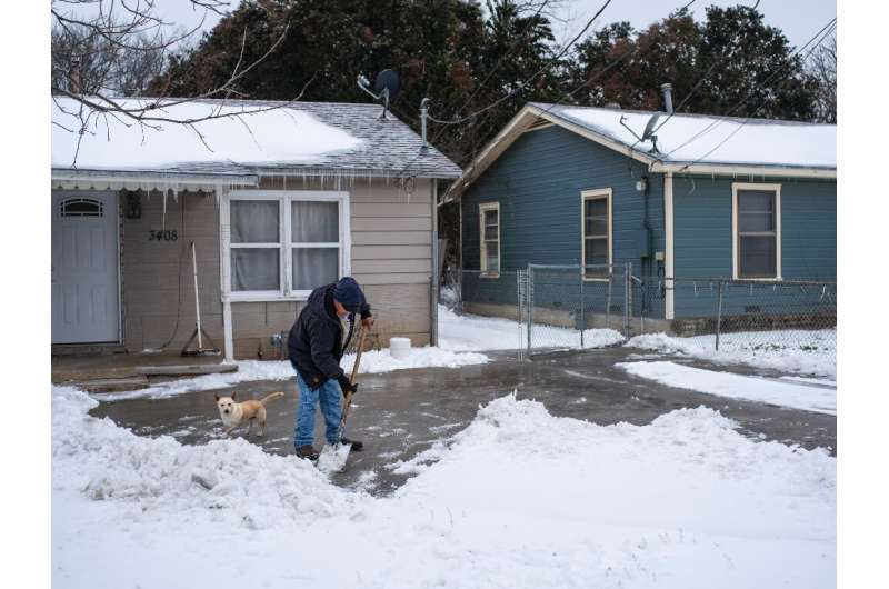 A resident in Waco, Texas clears snow as the oil-rich state struggles to cope with a historic cold snap