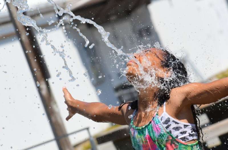 A child cools off at a community water park on a scorching hot day in Richmond, Canada