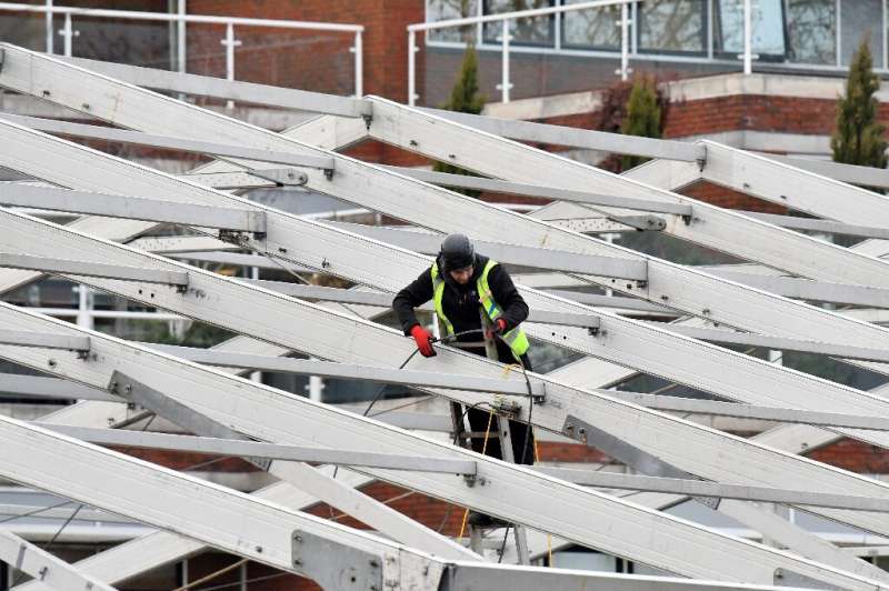 A construction worker erects a temporary field hospital in Tooting, south London, to contain a possible overspill of inpatients