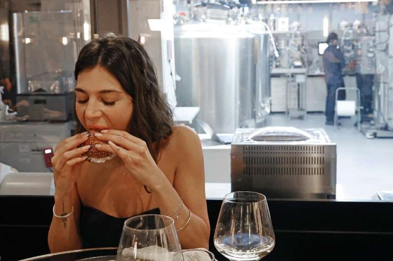 A diner eats a burger made with 'cultured chicken' meat at a restaurant adjoining the SuperMeat production site in the central I