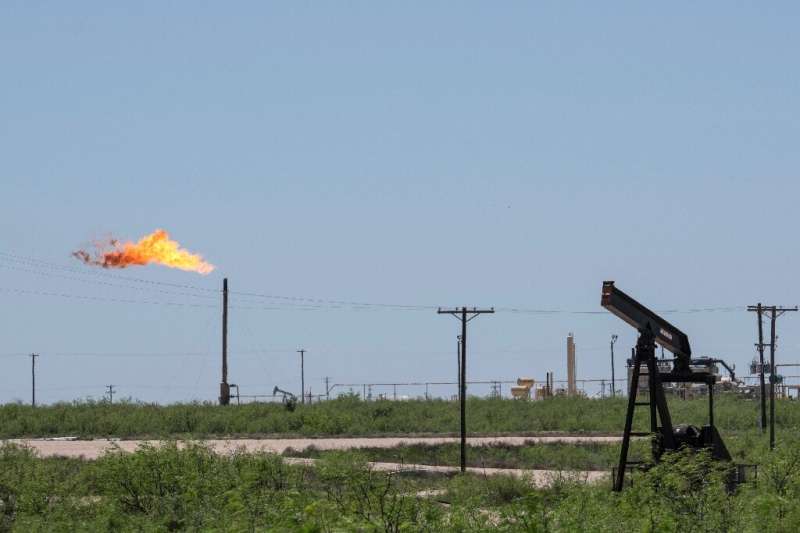 A flare stack is pictured next to pump jacks and other oil and gas infrastructure on April 24, 2020 near Odessa, Texas