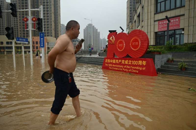 A man wades through a flooded street in  Zhengzhou