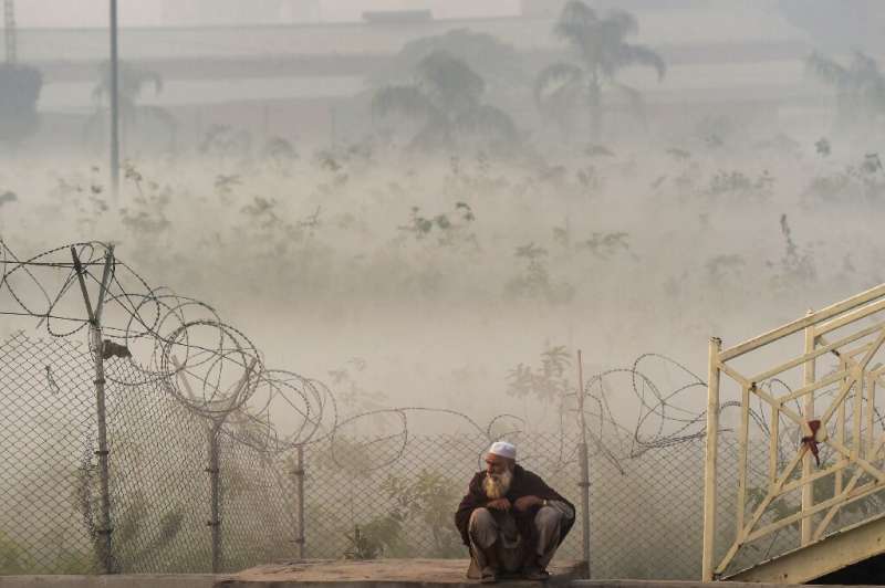 A man waits for transportation amid heavy smoggy conditions in Lahore, Pakistan on November 18, 2021