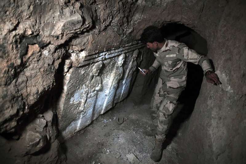 A member of the Iraqi military inspects artefacts in a tunnel dug by the Islamic State (IS) group near Mosul