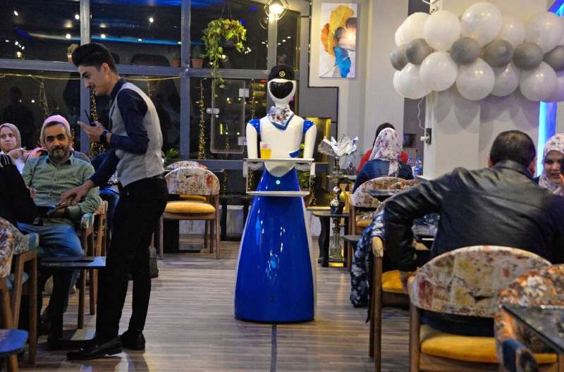 A robot waiter carries a bill to patrons of the White Fox restaurant in the northern Iraqi city of Mosul