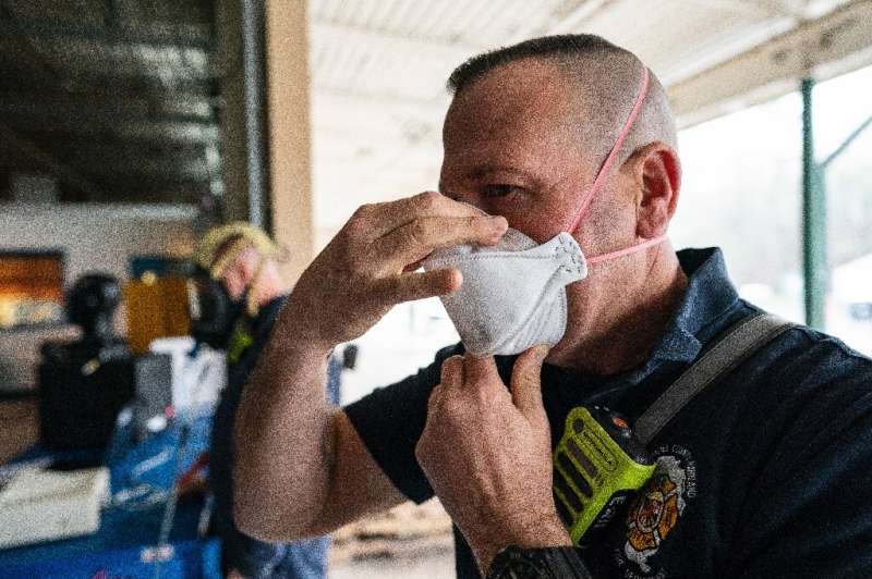 A firefighter with Anne Arundel County Fire Department in Maryland tests his N-95 mask