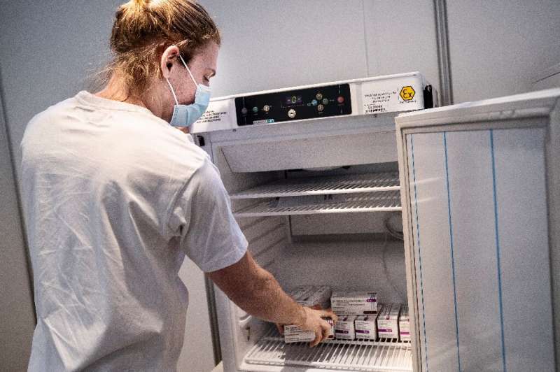 A medical staffer takes AstraZeneca vaccines out of the freezer at an inoculation center in Copenhagen