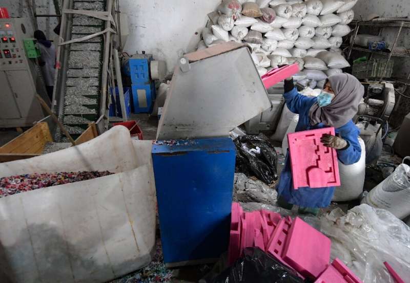 یک کارمند بازیافت آفریقا زباله های پلاستیکی را به آسیاب می دهد - بیشتر زباله ها در خیابان ها از کارخانه های غیررسمی جمع آوری می شود.