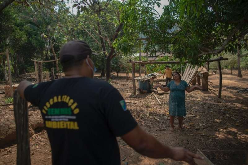 An employee of the Sao Felix do Xingu environment department talks to a farmer to find out who is behind an illegal fire in a ne