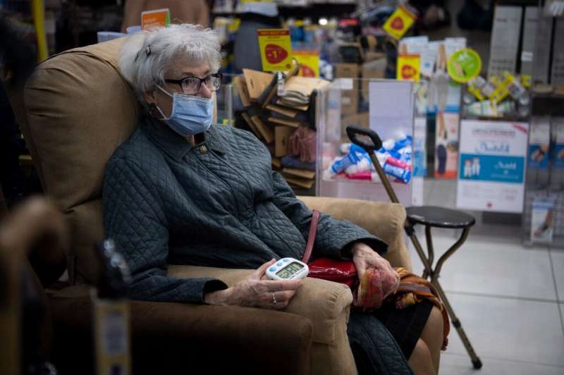 An elderly woman waits after being vaccinated with the AstraZeneca/Oxford Covid-19 vaccine, in a pharmacy in Nantes in western F