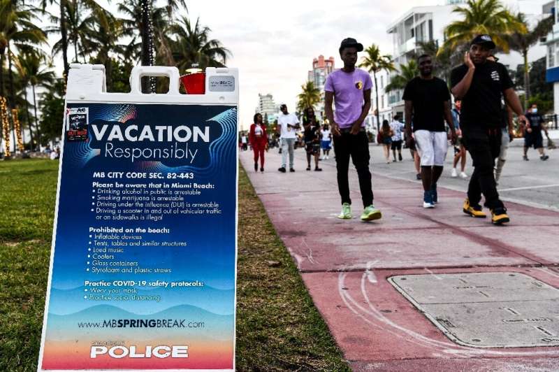 A sign asking vacationners to follow Covid-19 safety protocols in Miami Beach