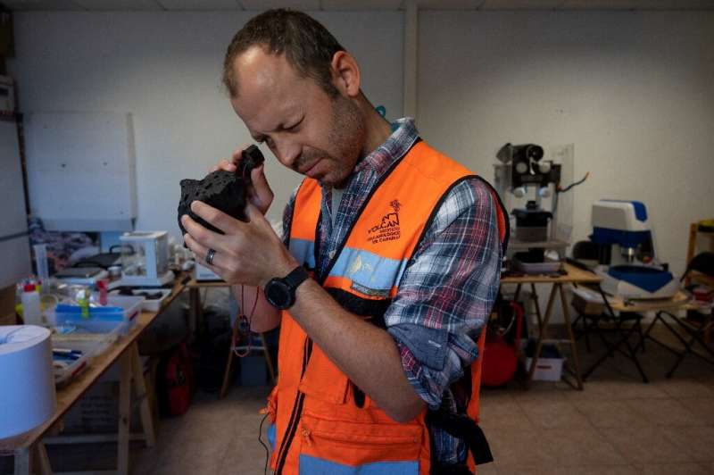 مت پانکهورست، زمین شناس استرالیایی، نمونه گدازه ای را در آزمایشگاه سنگی در نزدیکی لوس لانوس د آریدن بررسی می کند.