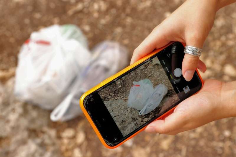 Before throwing her bags of garbage into a nearby bin, Ben Meir snaps pictures of her day's haul