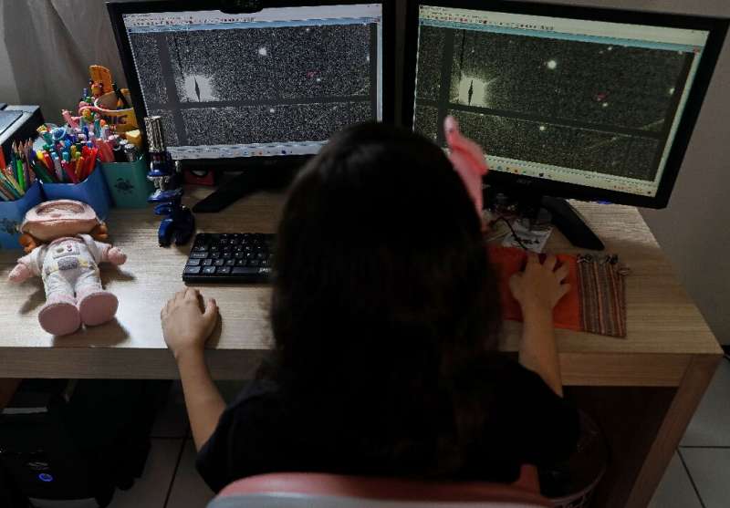 Brazilian 8-year-old astronomer Nicole Oliveira works on her computer at her house trying to discover asteroids as part of a NAS