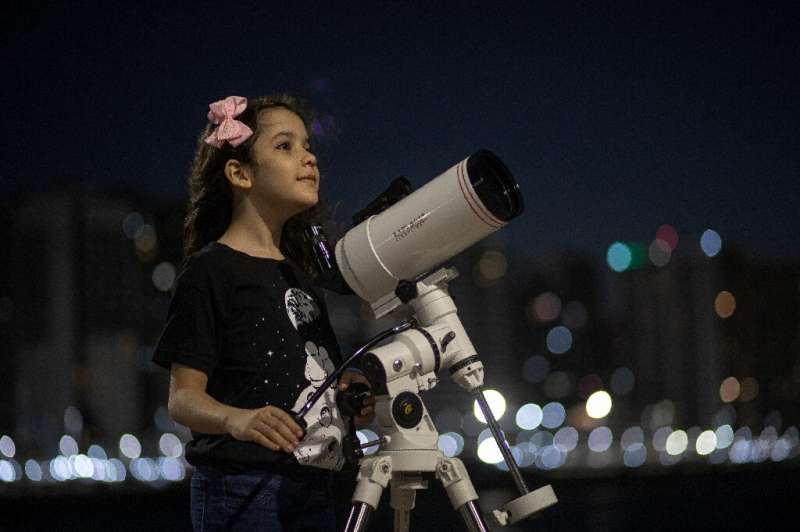 Brazilian 8-year-old astronomer Nicole Oliveira poses for a picture with her telescope in Fortaleza, Brazil, on September 21, 20