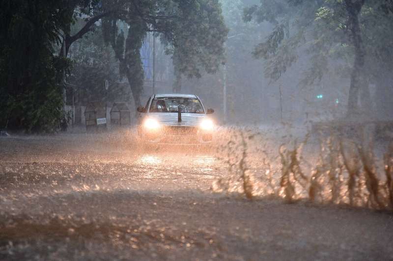 Commuters drive through a waterlogged road amidst heavy rains in Mumbai 
