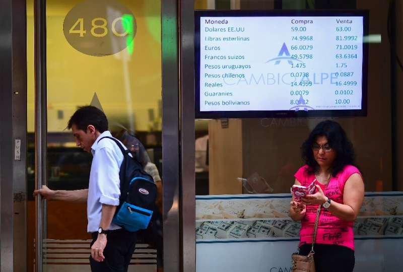 Currency exchange values are displayed on the buy-sell board of a bureau de exchange in Buenos Aires, on October 28, 2019