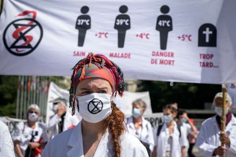 Doctors for Extinction Rebellion protesters march on the World Health Organization's headquarters in Geneva