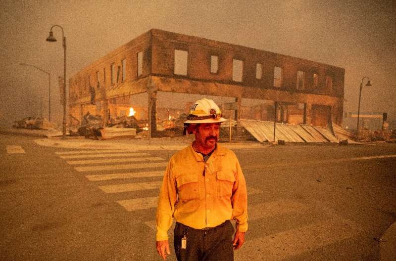 Il comandante dei vigili del fuoco Sergio Mora osserva mentre un incendio di Dixie si accende nel centro di Greenville, in California