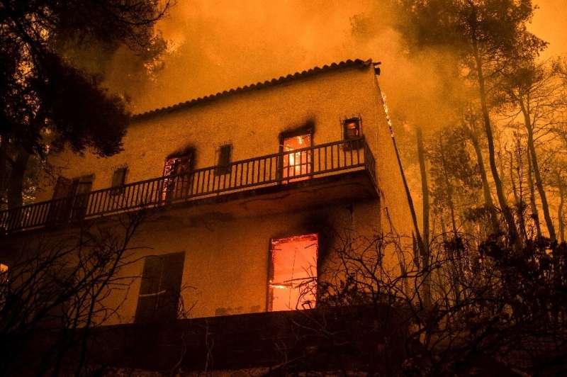 Firefighters try to stop Greek island blaze from reaching forest