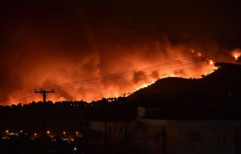 Flames rise from a fire spreading around Kapandriti, on the outskirts of Athens