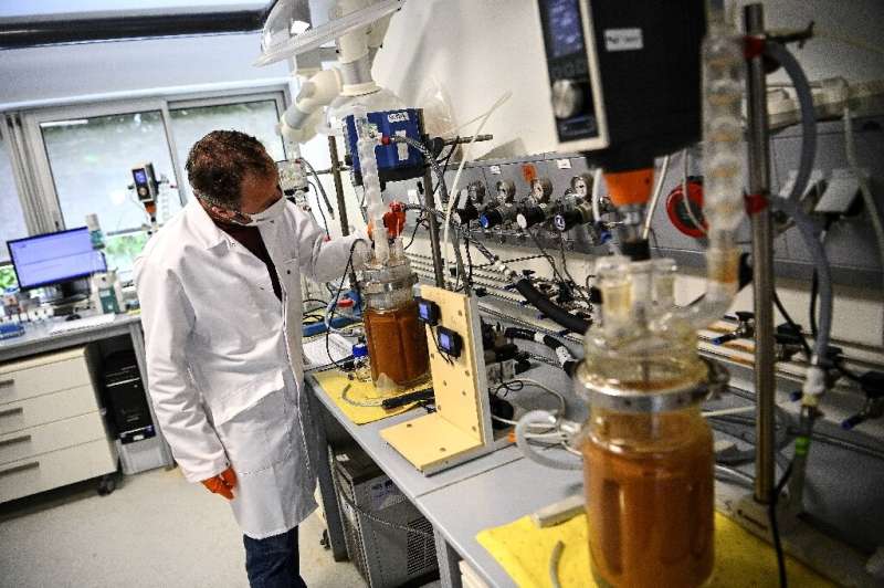 Glass jars containing pulverised electronics are injected with bacteria at a lab in western France by engineers aiming to extrac