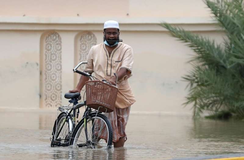 In this file photo taken on October 3, 2021 a man wades through a flooded street amid cyclone Shaheen in Oman's capital Muscat