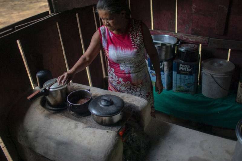 Jose Juliao do Nascimento's wife Dilva cooks on a wood oven at her home in Sao Felix do Xingu, in Brazil's Para state