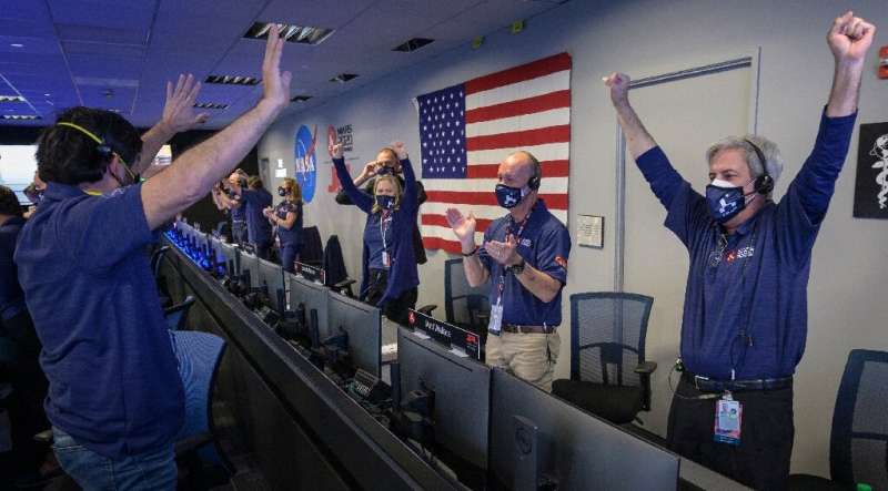 Members of NASA's Perseverance rover team react in mission control after receiving confirmation that the spacecraft successfully