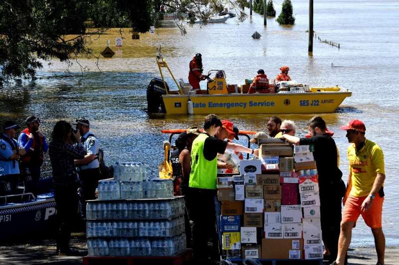 Members of the State Emergency Service transport relief goods during rescue operations at a flooded residential suburb of Sydney