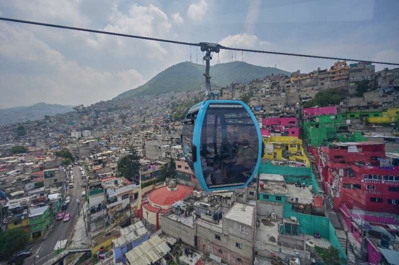 Passengers travel over Mexico City on the new  Cablebus aerial tramway