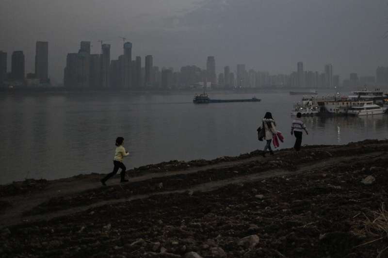 People walk in a park next to the Yangtze river in Wuhan on Wednesday